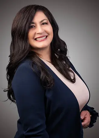Smiling woman with long dark hair wearing a navy blazer.